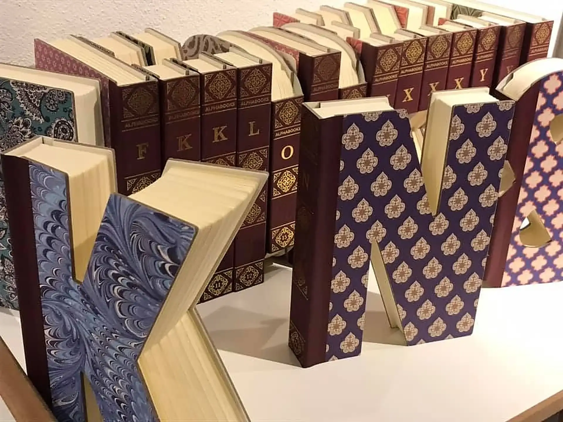 K�nstlerisch gestaltete Buchstaben aus dekorativen B�chern bei schauhi